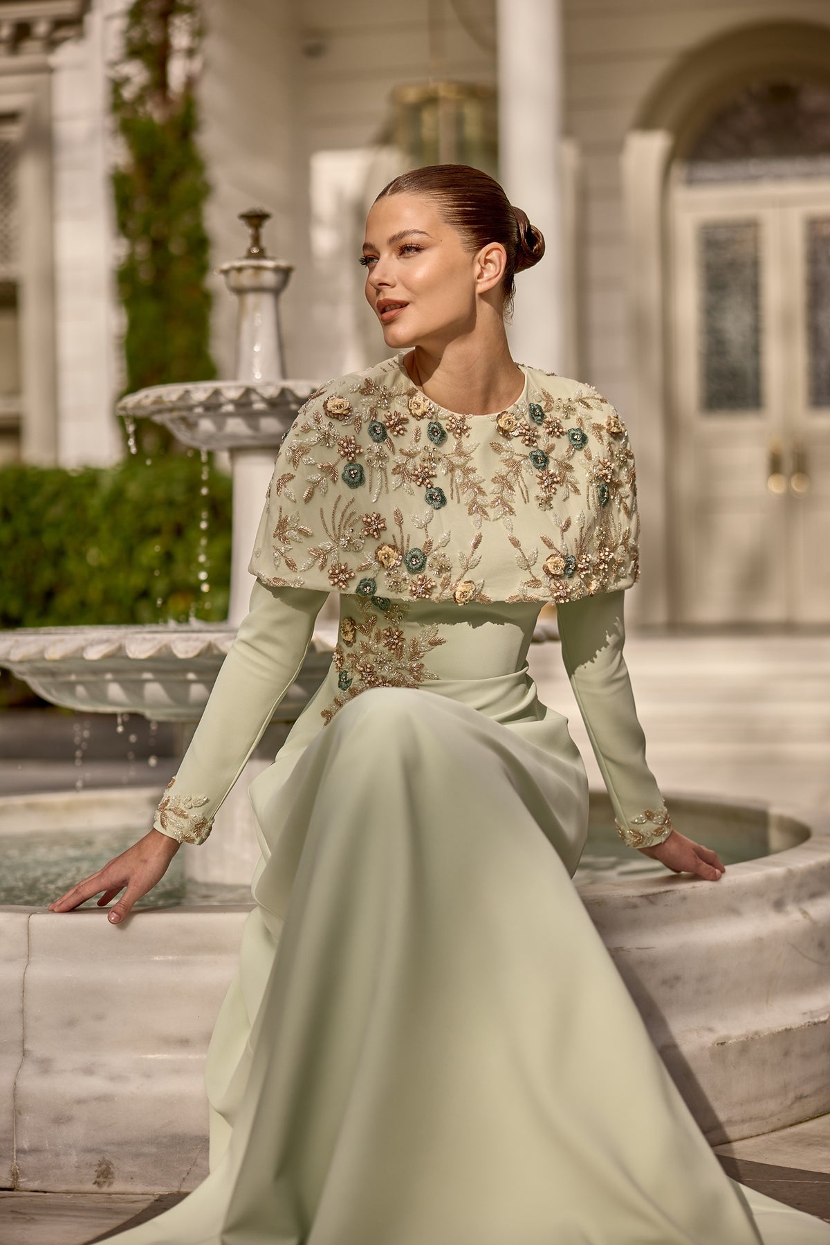 Couture inspired maxi dress designed with embellished details and statement cape styling