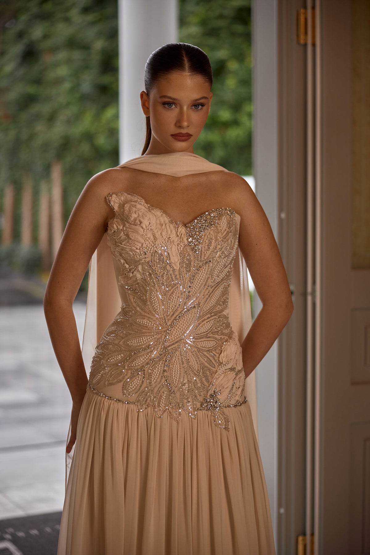 Luxury strapless evening dress featuring delicate embellishments and flowing scarf accent