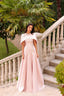 Blush pink couture evening dress with elegant cape detail and floral embellishments by Maison Harleen