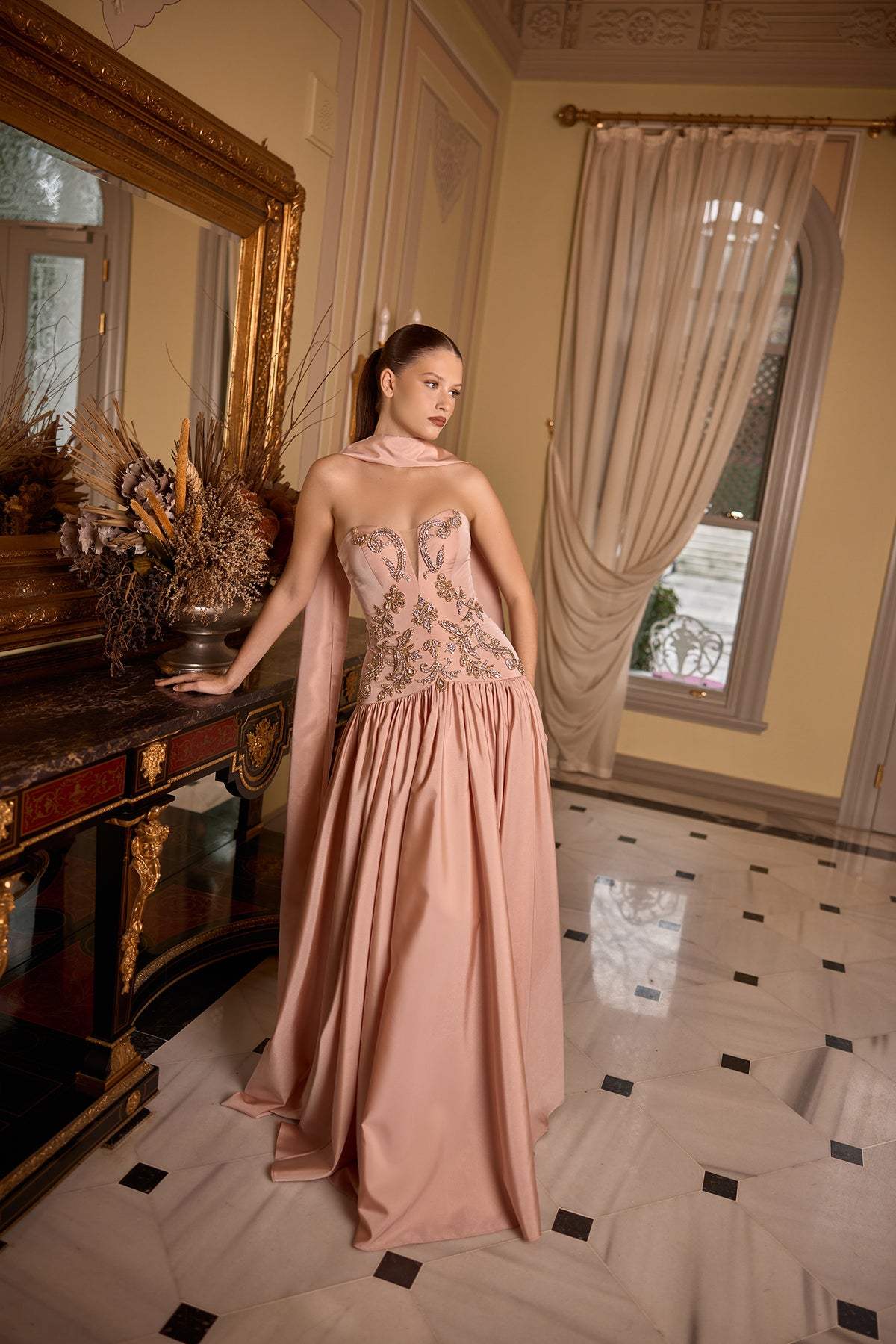 Model wearing Fern embroidered strapless evening gown with soft scarf detail and elegant silhouette