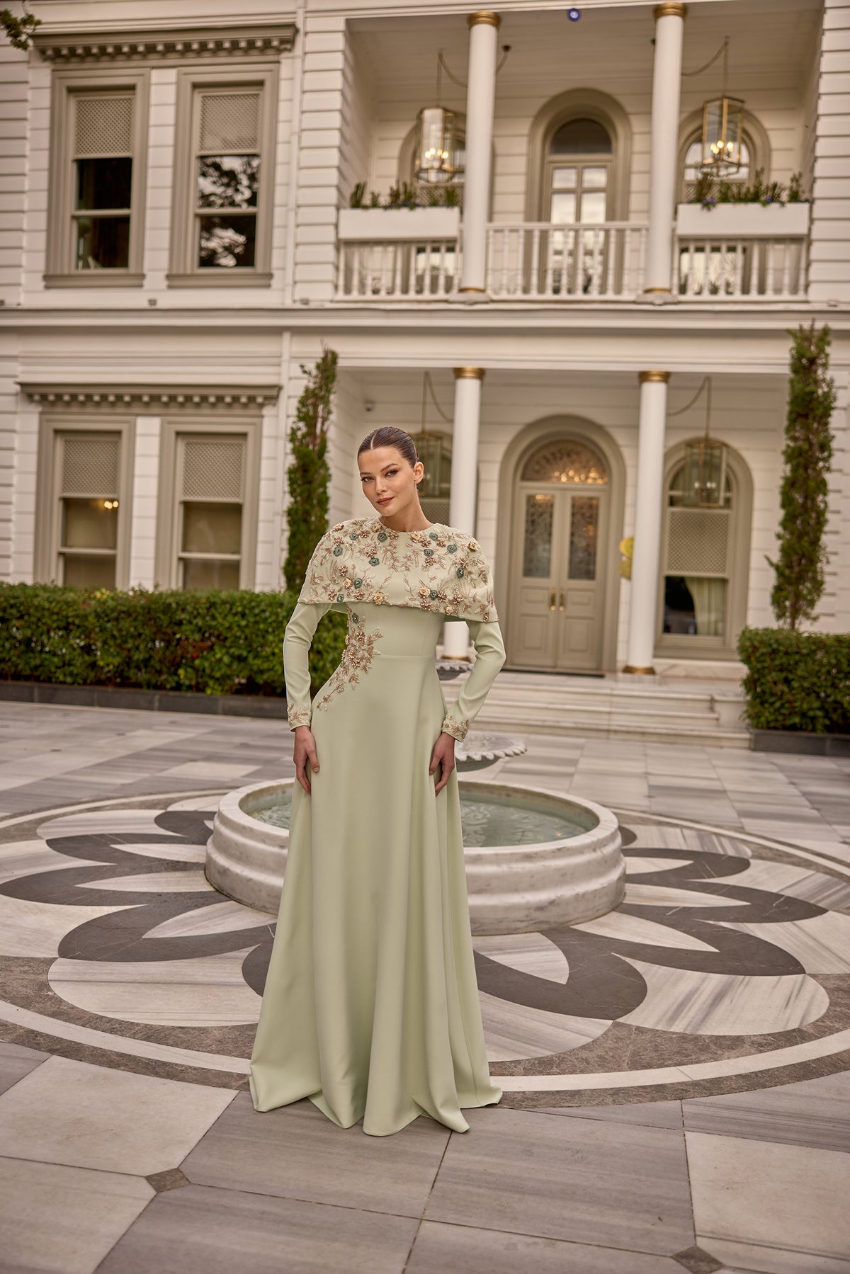 Luxury modest evening dress featuring elegant embellishments and dramatic floral cape