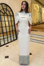 Minimalist ivory wedding gown with clean silhouette and structured cape sleeves