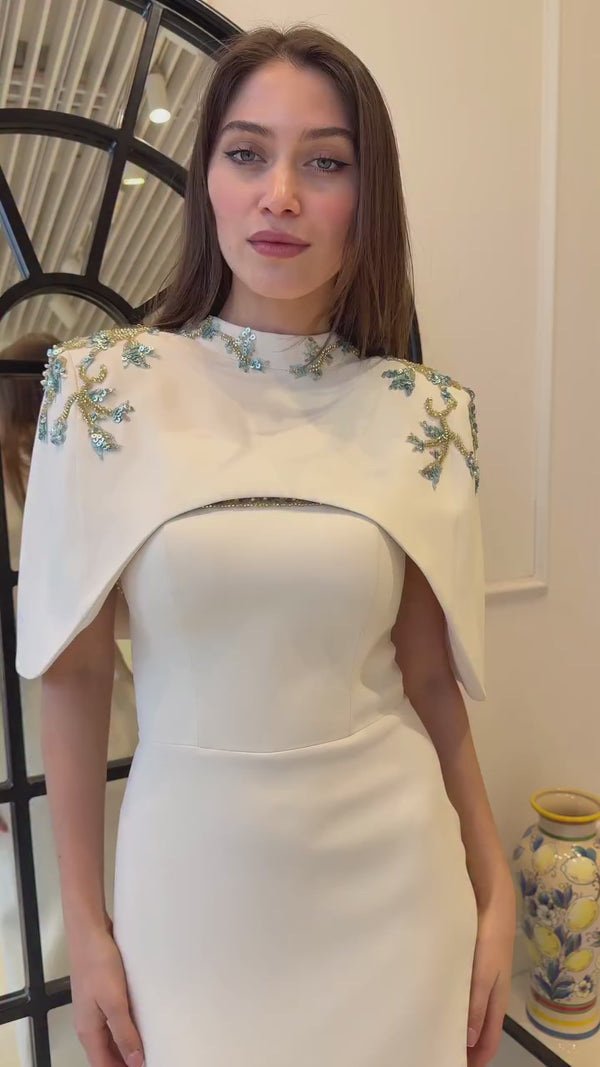 Modest bridal gown with high neckline, cape overlay and delicate shoulder embellishments
